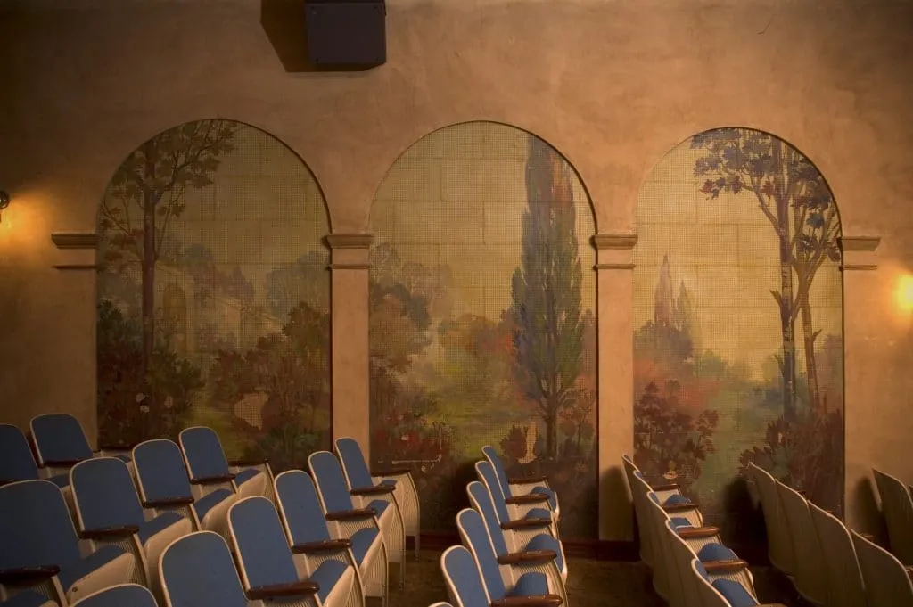 Grand historic theatre with red velvet curtain and ornate architecture