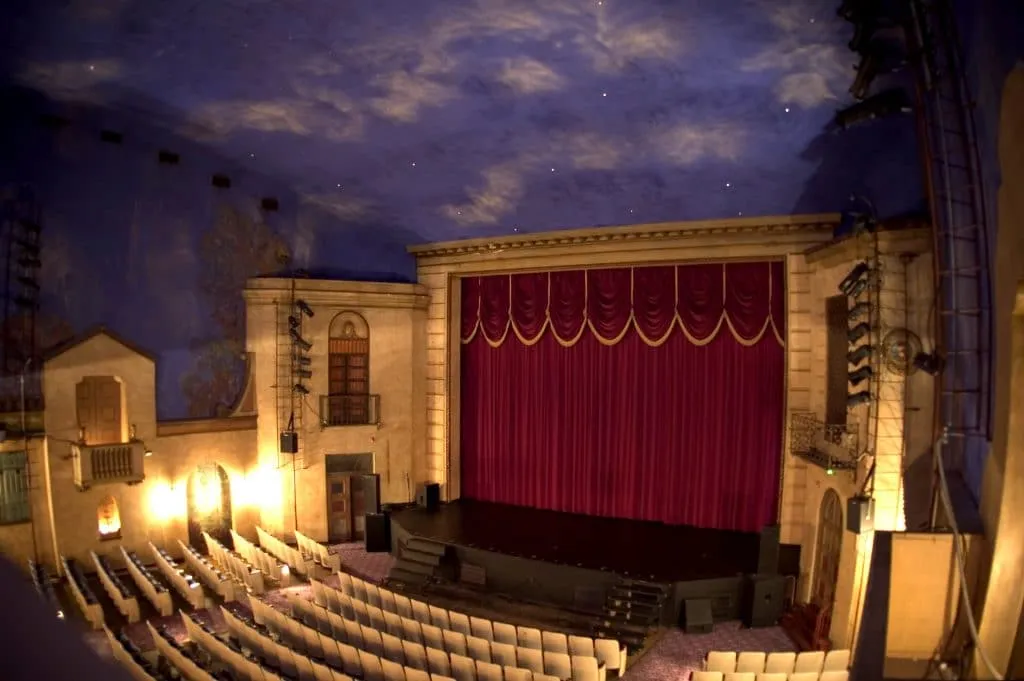 Live band performance with dramatic stage lighting and silhouetted audience
