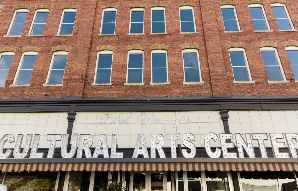 Straight-on shot of large letters balancing on entrance to building that say 'Cultural Arts Center'