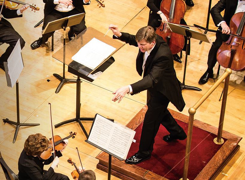 Male conductor leading orchestra